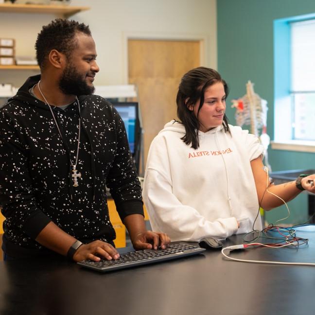 Two students perform an experiment in lab